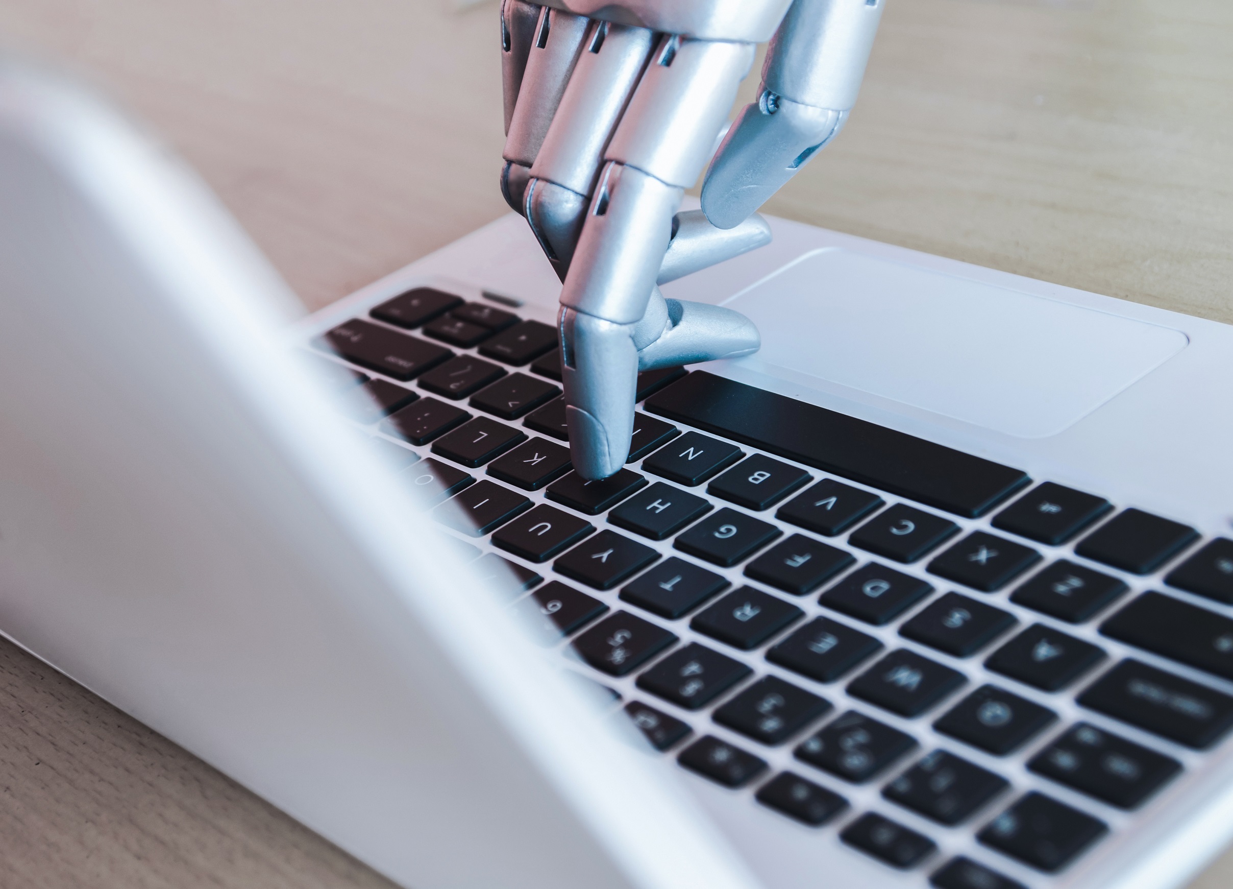 Robot hand on a keyboard, showcasing AI-driven SEO.